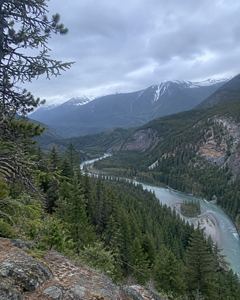 Example phone photo: a river valley between forested mountains under a grey sky