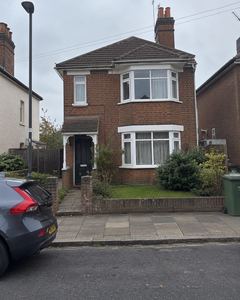 Example phone photo: a red-brick house on a grey day, with a car parked in front