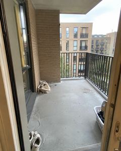 Example phone photo: a bare concrete balcony with a laundry basket