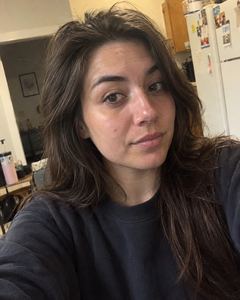 Example phone photo: a selfie of a woman with long dark hair in her kitchen