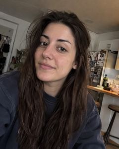 Example phone photo: a selfie of a woman with long dark hair in her kitchen